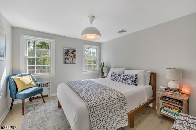 bedroom featuring light wood-type flooring and radiator