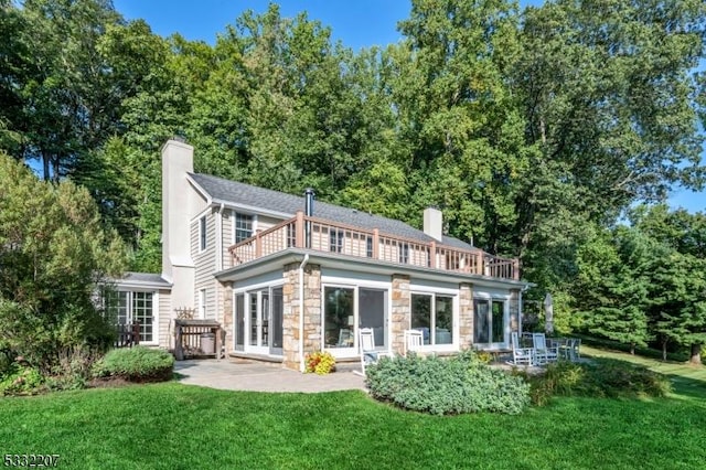 rear view of property with a patio area, a yard, and a balcony