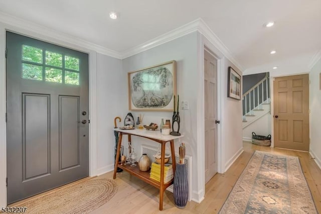 foyer entrance featuring light wood-type flooring and crown molding