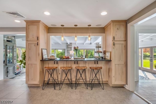 bar featuring hanging light fixtures, french doors, and light brown cabinets