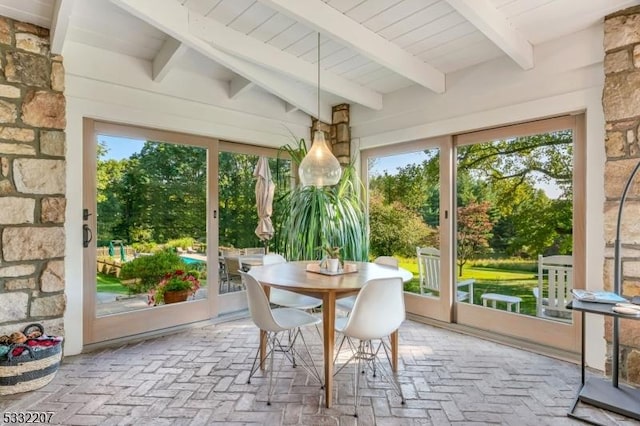 sunroom / solarium featuring beamed ceiling