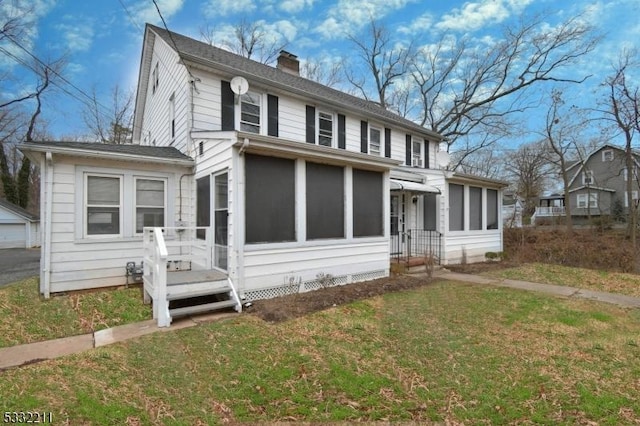 view of front of home with a front lawn and a sunroom