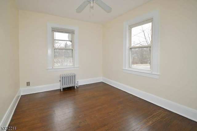 unfurnished room with ceiling fan, radiator, and dark hardwood / wood-style flooring