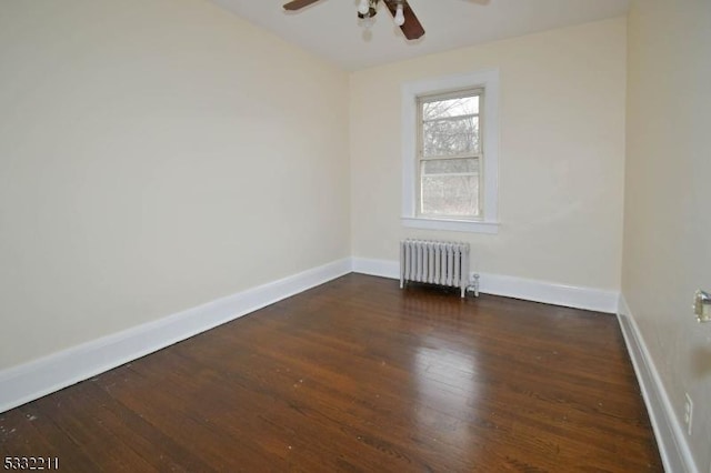 spare room with ceiling fan, radiator heating unit, and dark hardwood / wood-style flooring