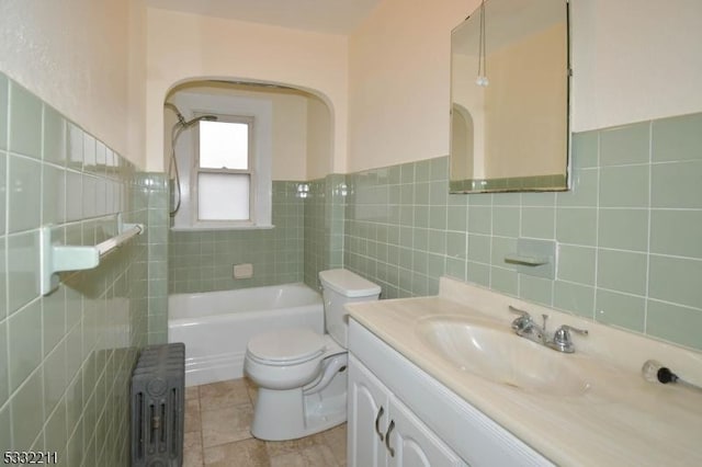 full bathroom with radiator, toilet, tile walls, and vanity