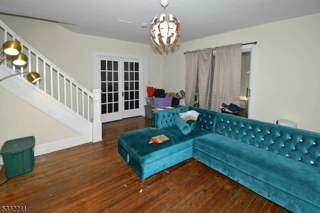 living room with dark hardwood / wood-style floors, a chandelier, and french doors