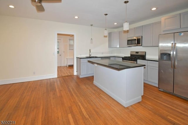 kitchen with decorative light fixtures, sink, gray cabinetry, and stainless steel appliances