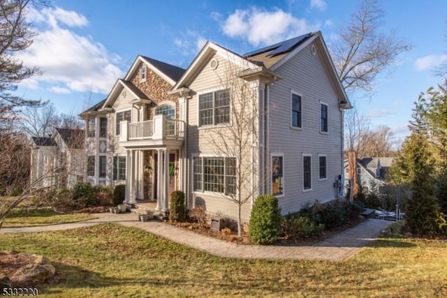 front of property featuring a balcony and a front yard