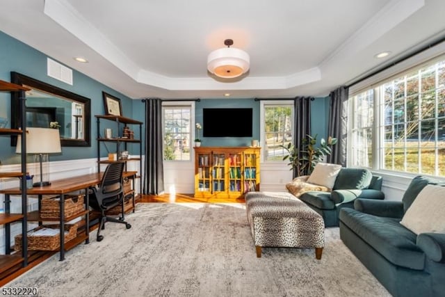 home office with a raised ceiling, ornamental molding, and hardwood / wood-style floors