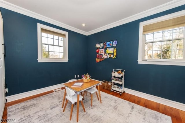 dining area with wood-type flooring and crown molding