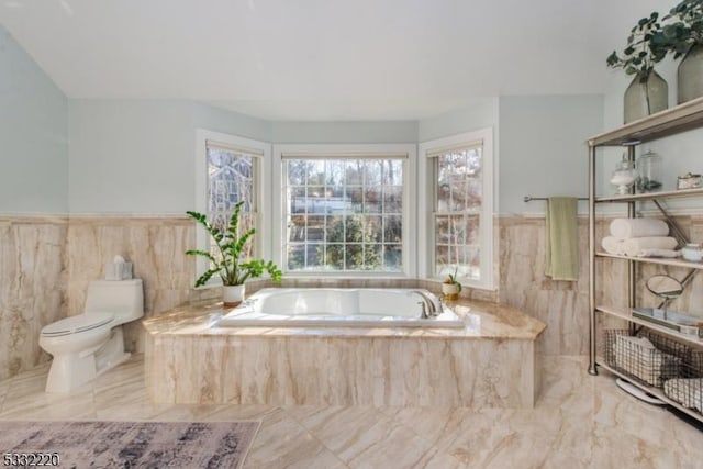 bathroom featuring toilet and a relaxing tiled tub