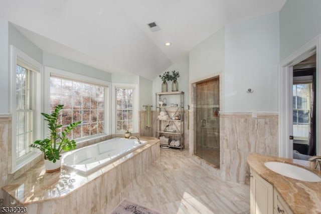 bathroom with vanity, separate shower and tub, and vaulted ceiling