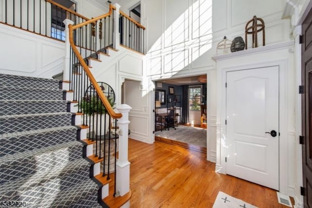 stairway featuring hardwood / wood-style floors and a towering ceiling