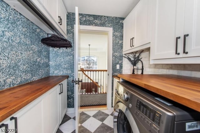 washroom with cabinets, washer / dryer, and a chandelier