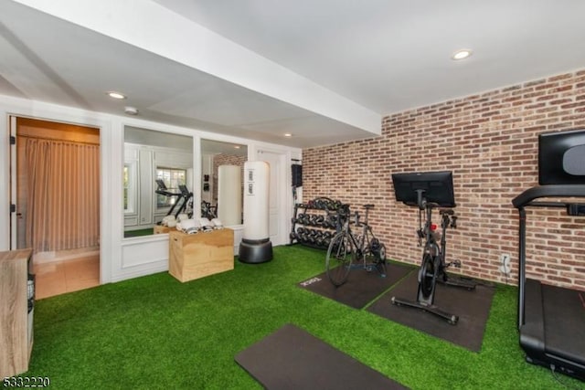 workout room featuring brick wall and carpet flooring