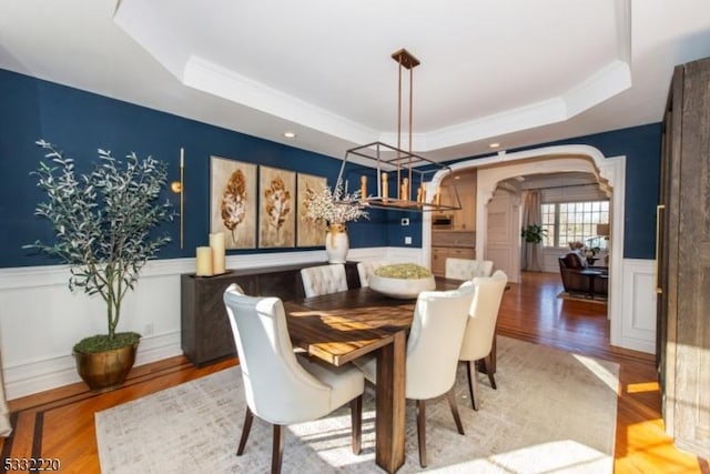 dining area featuring hardwood / wood-style flooring and a raised ceiling