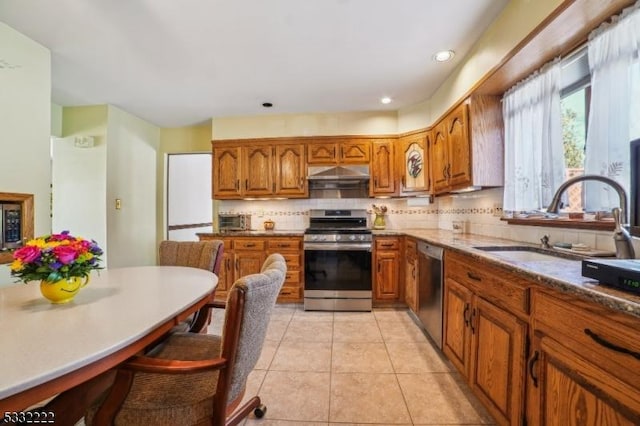 kitchen with stainless steel appliances, wall chimney exhaust hood, decorative backsplash, and sink