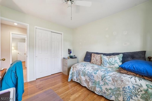 bedroom with hardwood / wood-style flooring, ceiling fan, and a closet