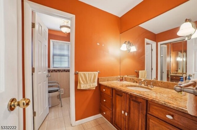 bathroom with toilet, tile patterned flooring, and vanity