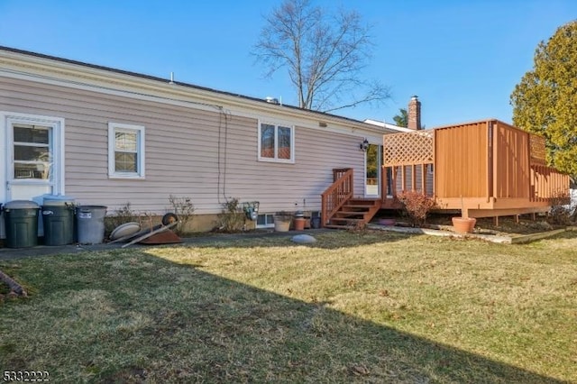 rear view of property with a deck and a lawn