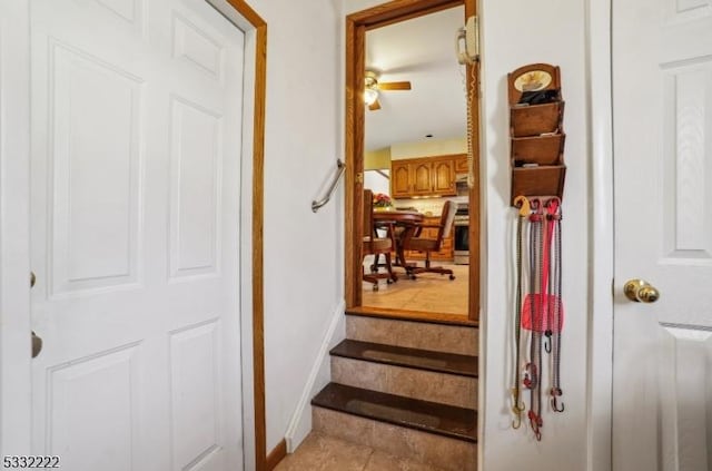 staircase featuring tile patterned floors and ceiling fan