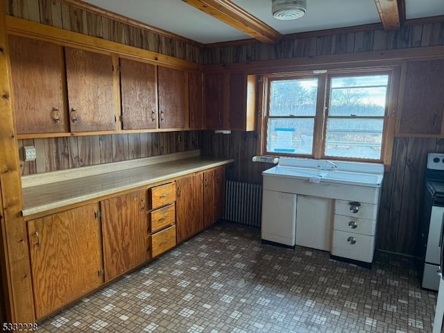 kitchen with range with electric stovetop, wood walls, radiator heating unit, and beamed ceiling