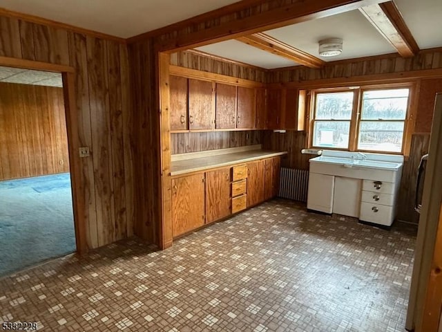 kitchen featuring refrigerator, wooden walls, and beamed ceiling