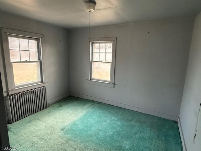 unfurnished room with carpet floors and radiator