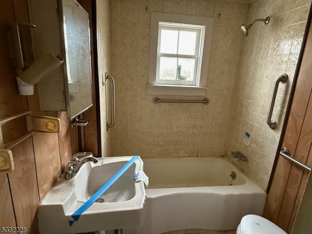 full bathroom with sink, tiled shower / bath combo, and toilet