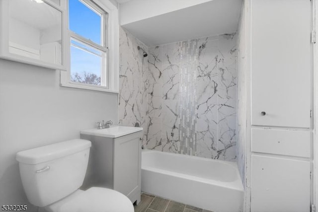 full bathroom with toilet, tiled shower / bath, and vanity