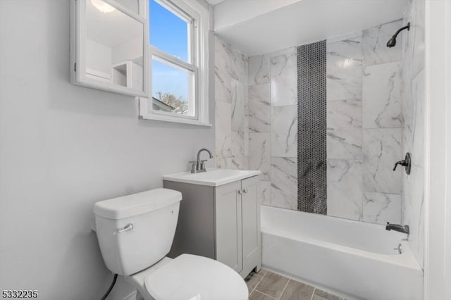 full bathroom with tiled shower / bath, vanity, and toilet