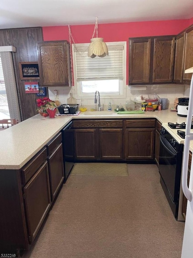 kitchen featuring gas range oven, tasteful backsplash, dark brown cabinetry, and sink