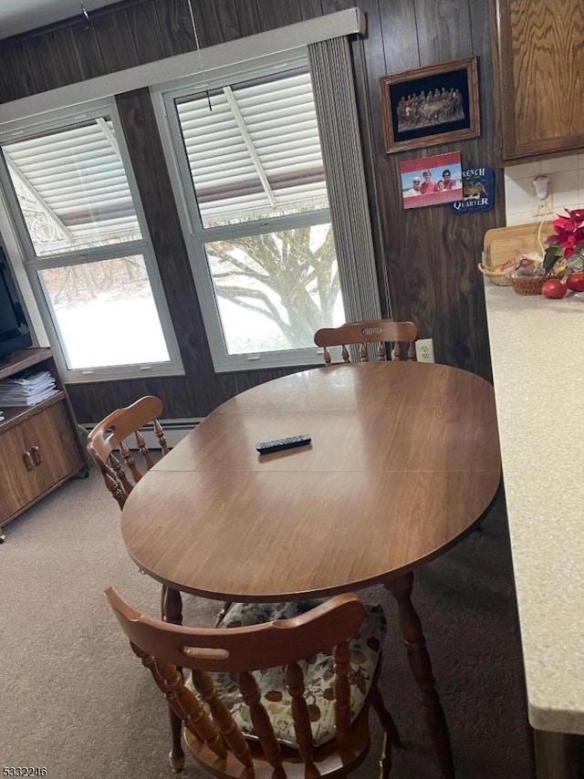 carpeted dining room with wood walls