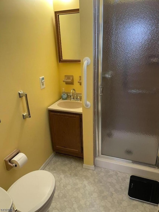 bathroom featuring toilet, an enclosed shower, and vanity