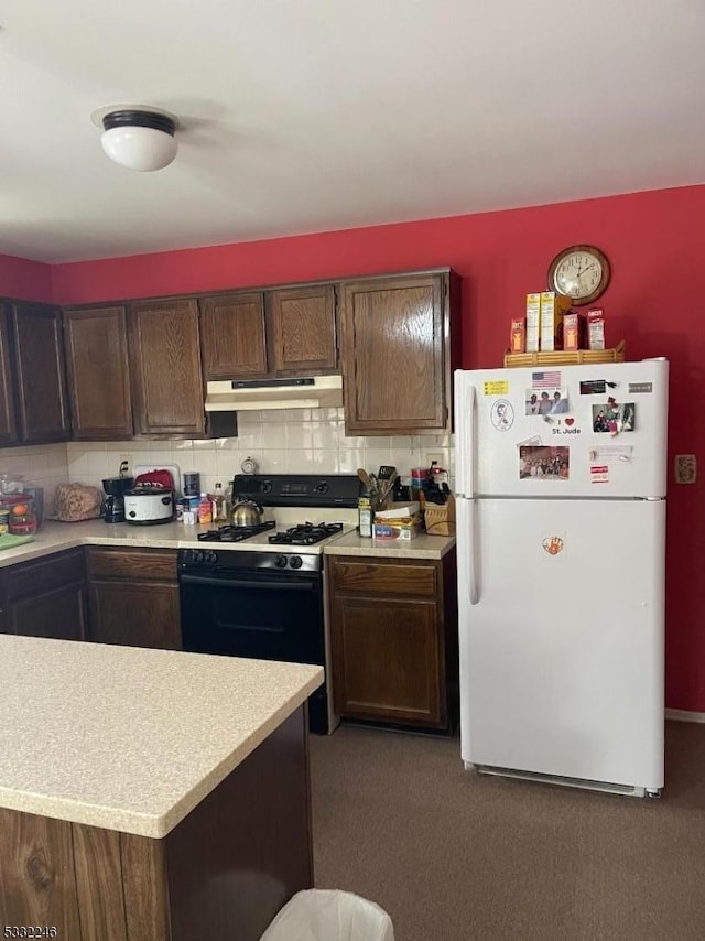 kitchen featuring dark brown cabinets, white refrigerator, decorative backsplash, and gas stove