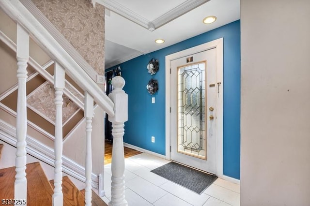 tiled foyer featuring crown molding