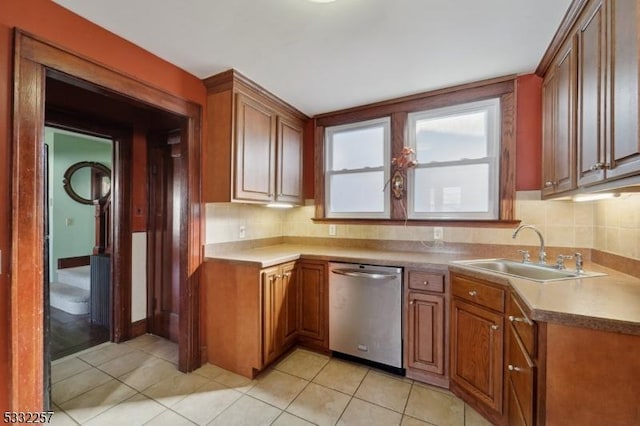 kitchen with dishwasher, sink, light tile patterned flooring, and backsplash