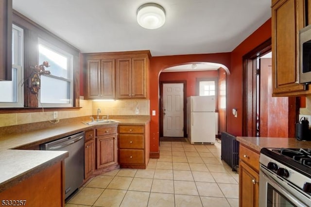 kitchen featuring sink, light tile patterned flooring, a healthy amount of sunlight, and appliances with stainless steel finishes