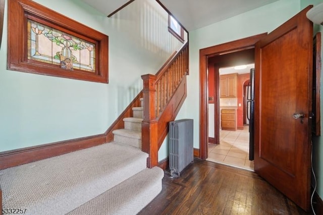 stairs with radiator heating unit and hardwood / wood-style floors