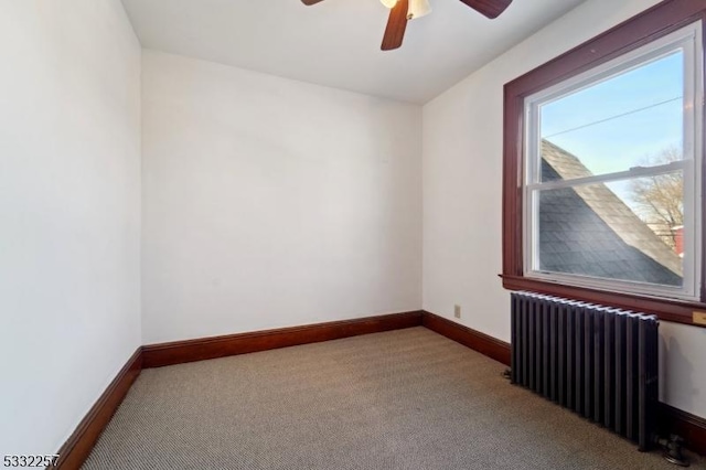 unfurnished room with radiator heating unit, light colored carpet, and ceiling fan