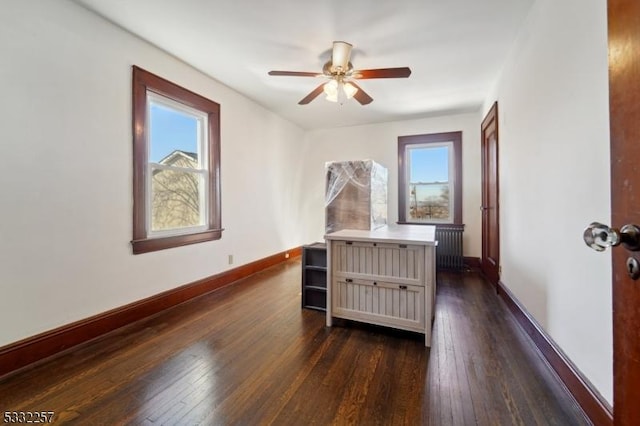 bedroom with ceiling fan, radiator, and dark hardwood / wood-style flooring