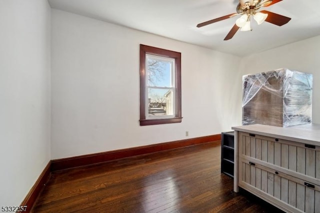 empty room with dark hardwood / wood-style flooring and ceiling fan