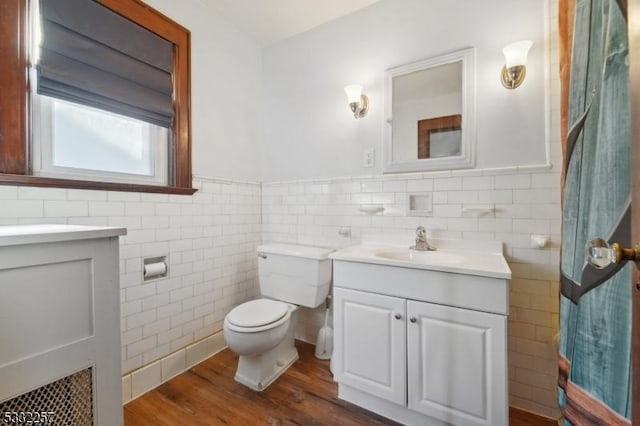 bathroom with vanity, hardwood / wood-style flooring, tile walls, and toilet