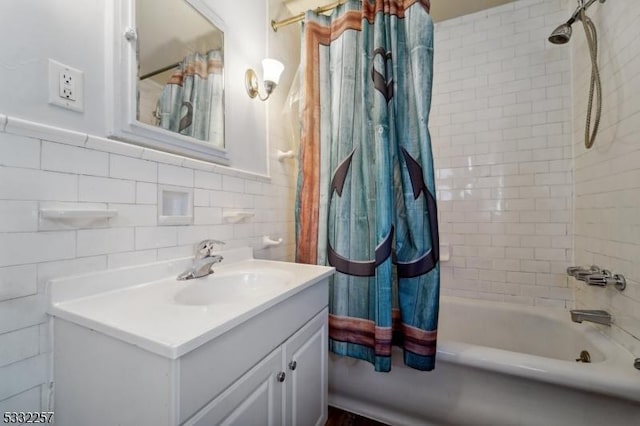 bathroom featuring vanity, tile walls, and shower / bath combo