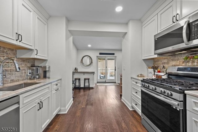 kitchen featuring dark hardwood / wood-style flooring, sink, white cabinets, and appliances with stainless steel finishes