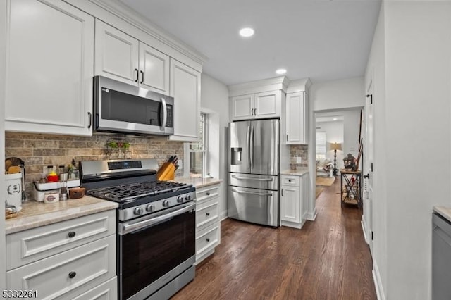 kitchen featuring white cabinetry, appliances with stainless steel finishes, dark hardwood / wood-style floors, and decorative backsplash