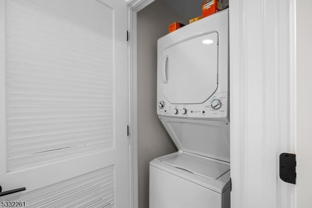 clothes washing area with stacked washer and dryer