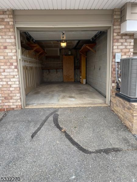 garage featuring cooling unit and a garage door opener