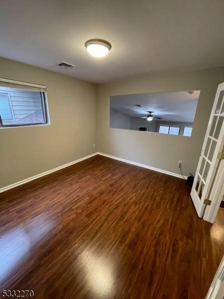 unfurnished room with ceiling fan and dark hardwood / wood-style flooring