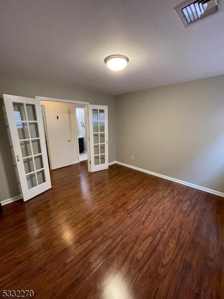 spare room with french doors and dark hardwood / wood-style flooring